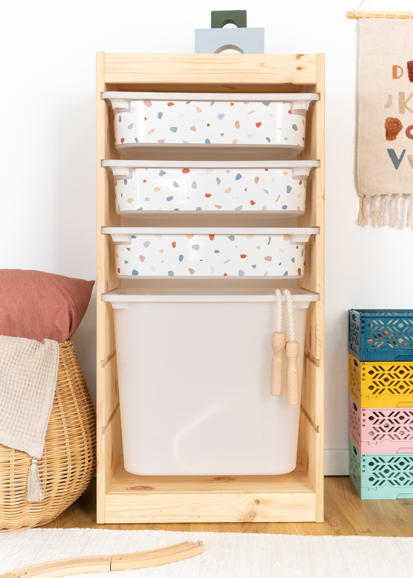 Kinderfreundliche Box im IKEA TROFAST Regal, beklebt mit einer farbenfrohen Terrazzo-Folie. Buntes Terrazzo-Muster auf Klebefolie im IKEA TROFAST Regal