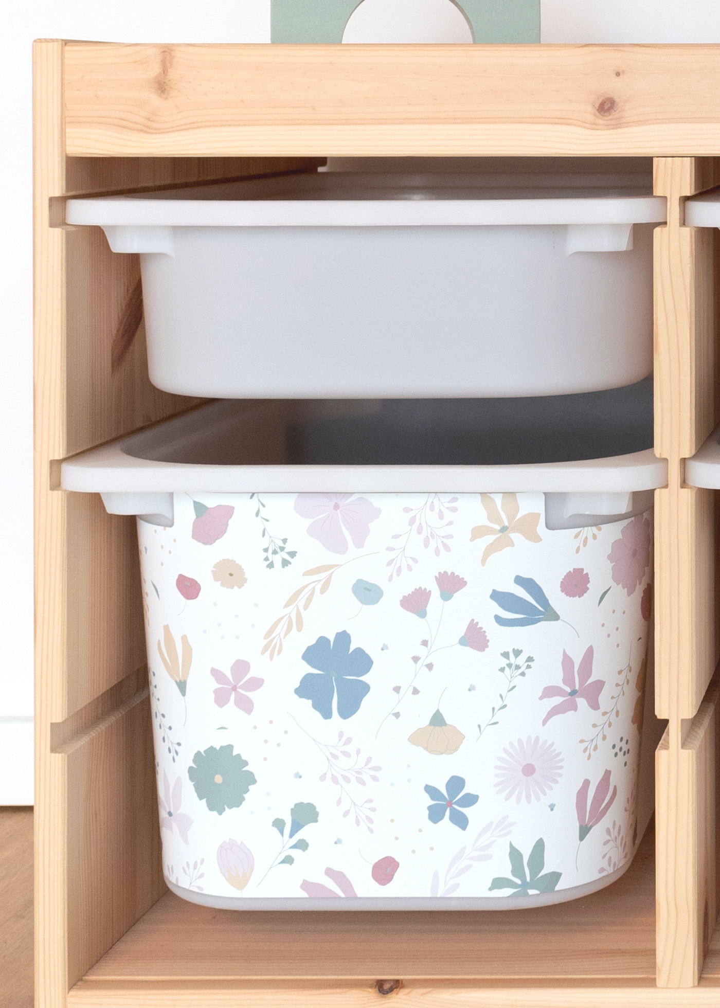 Blumenmuster auf Klebefolie für IKEA TROFAST Ein IKEA TROFAST Regal im Zimmer, verziert mit einer bunten Blumenmuster-Klebefolie