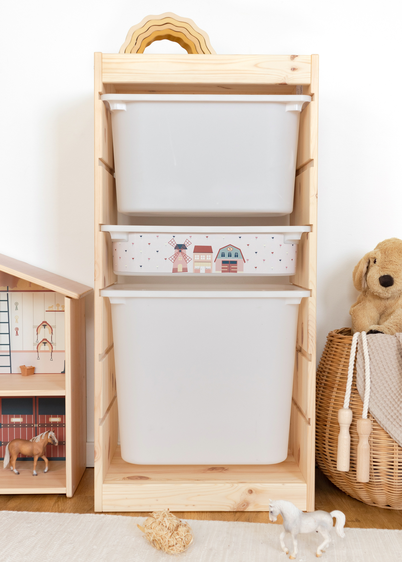 IKEA TROFAST Regal mit rosa Box, dekoriert mit einem Dorf-Motiv für das Kinderzimmer.