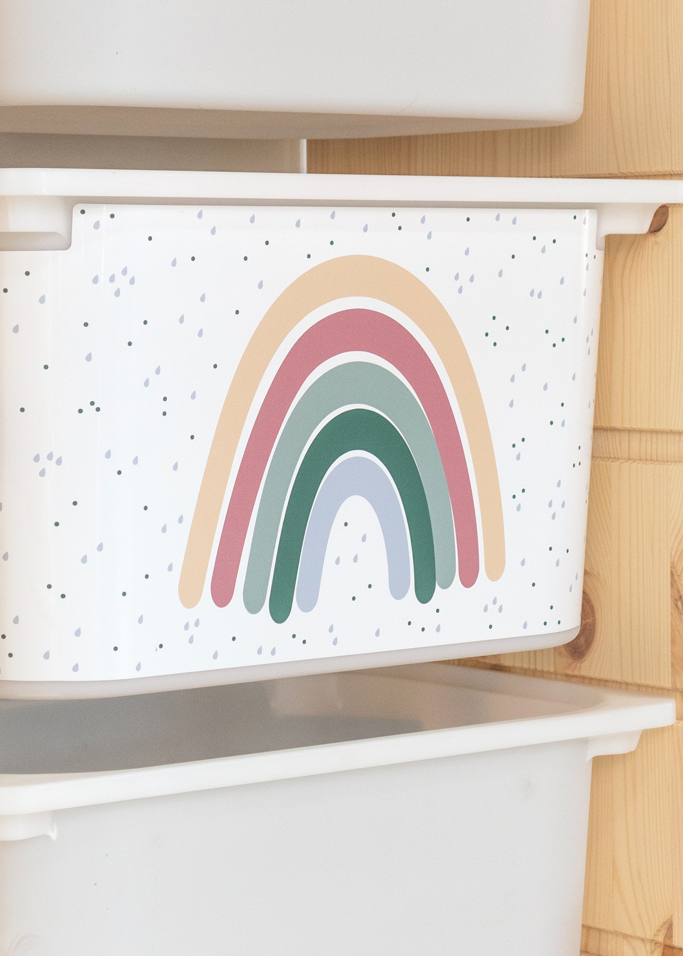 Aufbewahrungsbox im IKEA TROFAST Regal, dekoriert mit einem großen bunten Regenbogen für das Kinderzimmer.