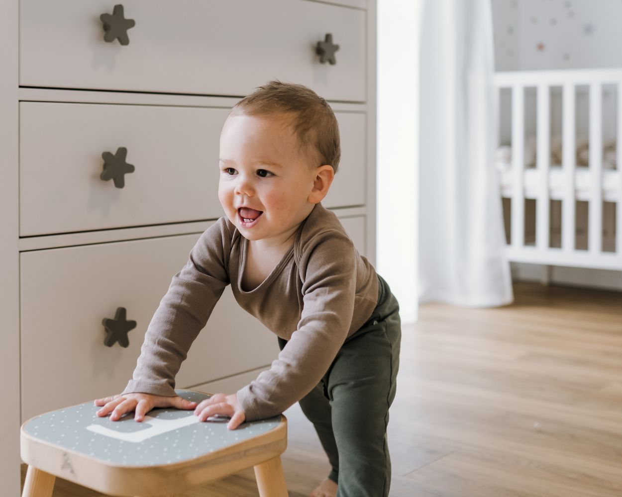 Junge spielt im Babyzimmer mit IKEA Hocker