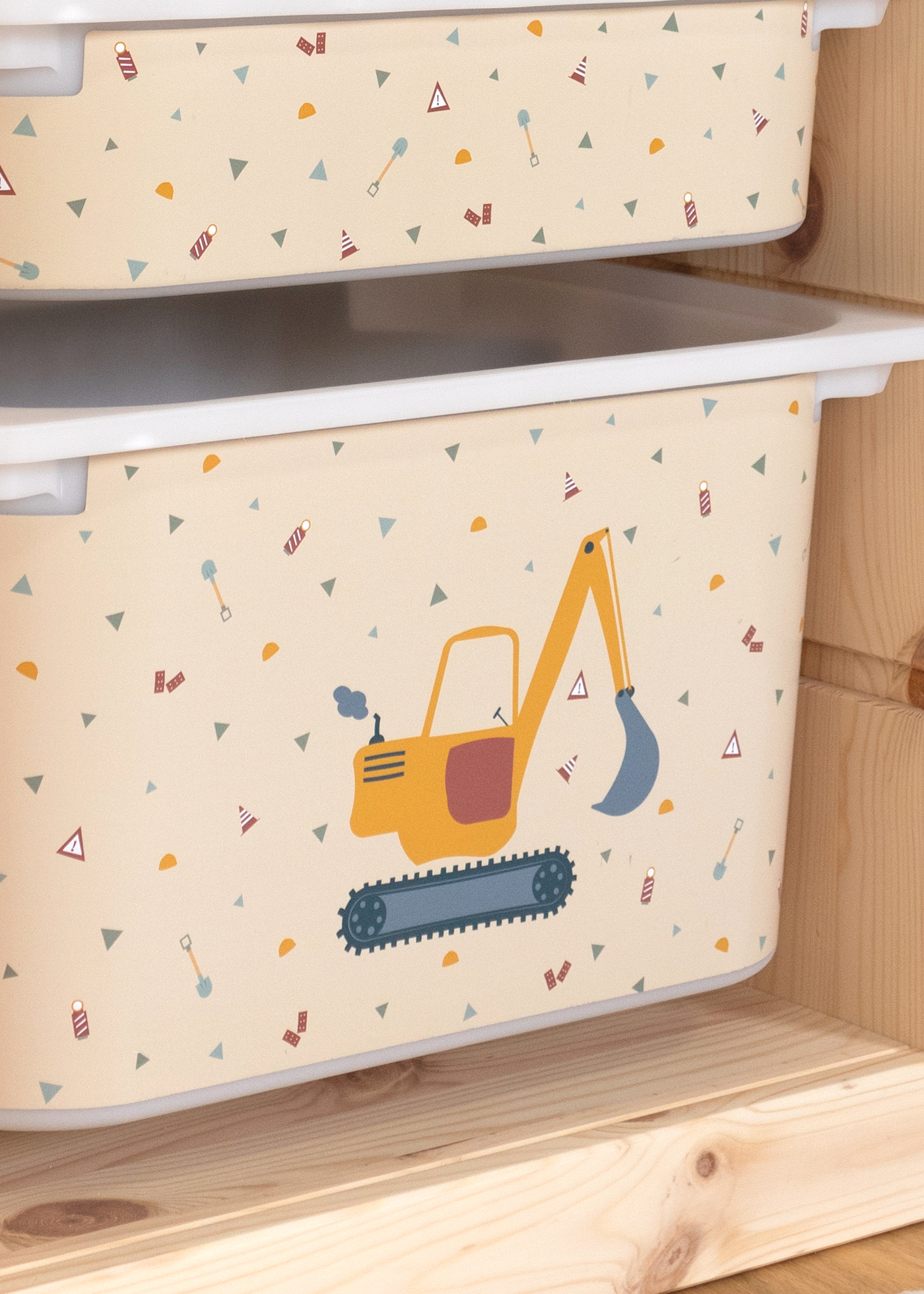 Bagger-Motiv auf beige Box im IKEA TROFAST Regal, ideal für Kinderzimmer.