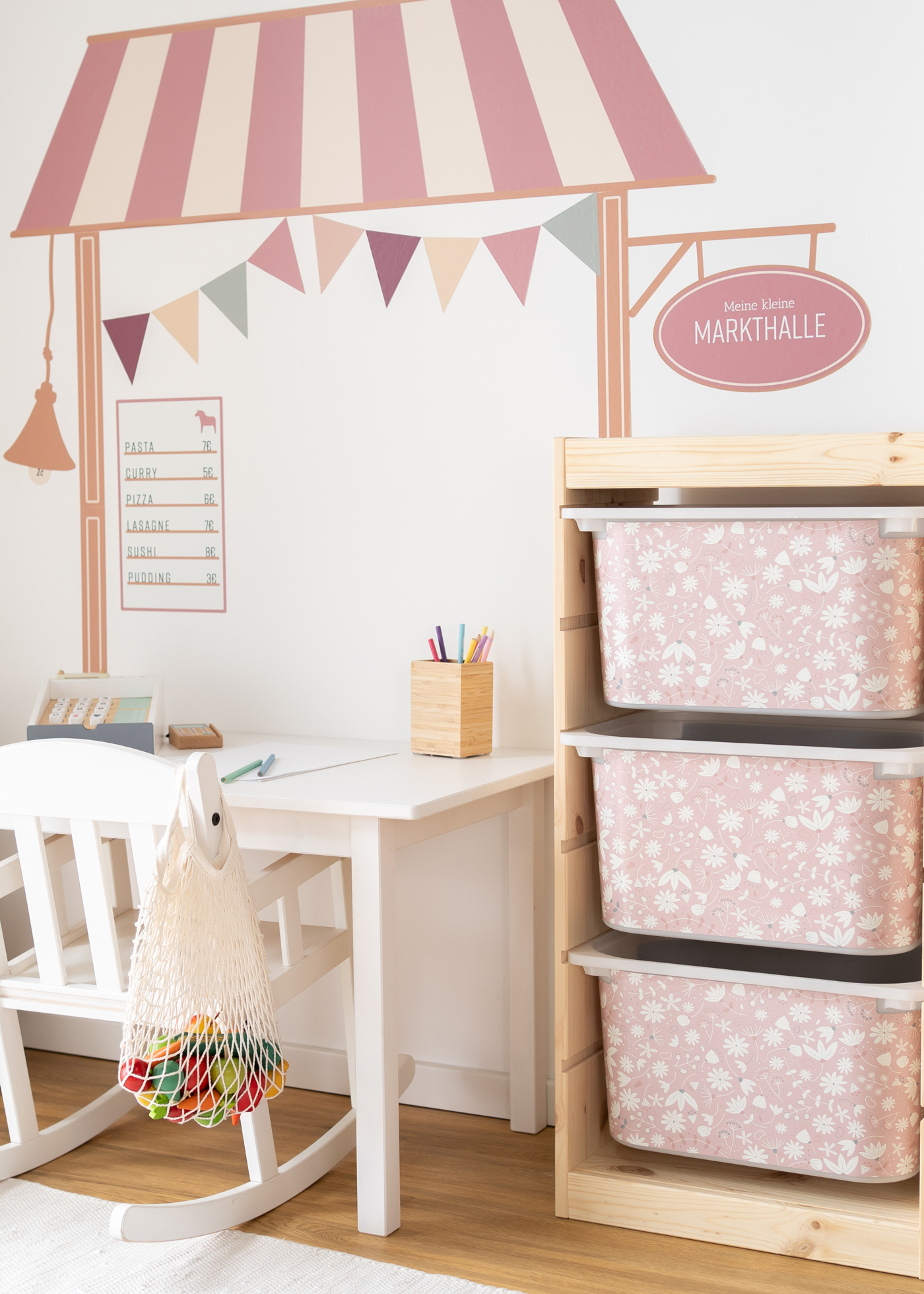 Rosa Blumenmuster auf Aufbewahrungsbox im IKEA TROFAST Regal Kinderfreundliche Box im IKEA TROFAST Regal, bedruckt mit einem verspielten rosa Blumenmuster.