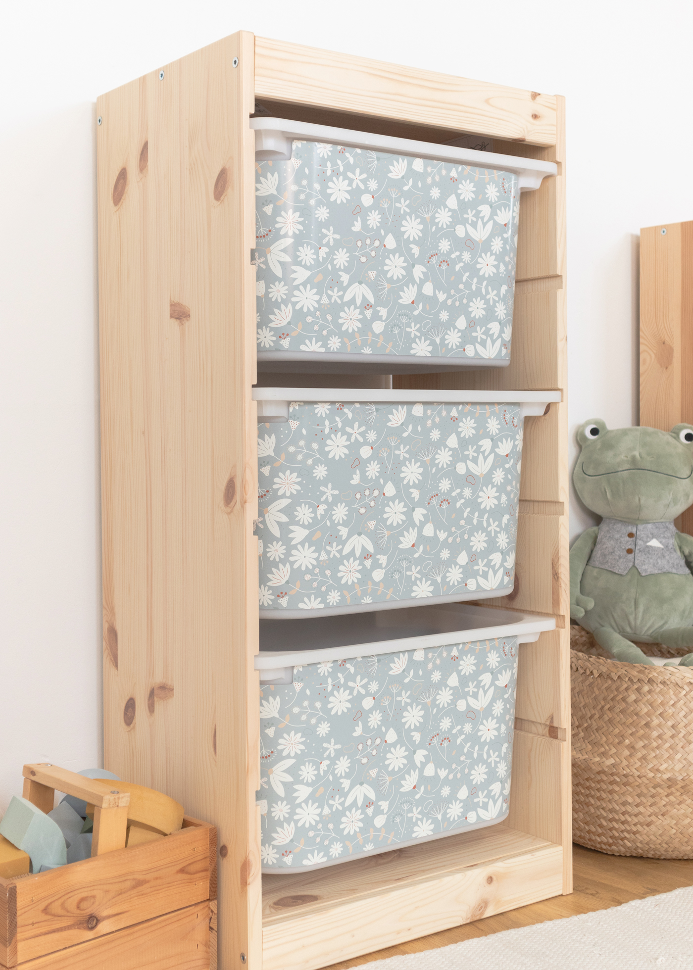 Dekorative Aufbewahrungsbox mit grünem Blumenmuster im IKEA TROFAST Regal Aufbewahrungsbox im IKEA TROFAST Regal, verziert mit einem verspielten grünen Blumenmuster.