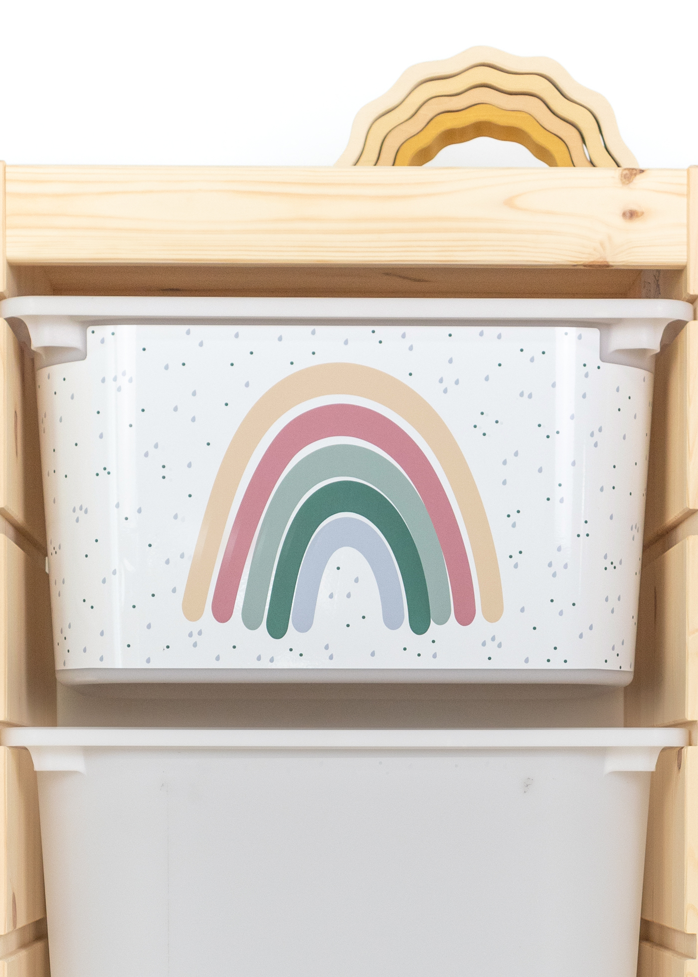 Praktische beige Box im IKEA TROFAST Regal, dekoriert mit einem Regenbogen.