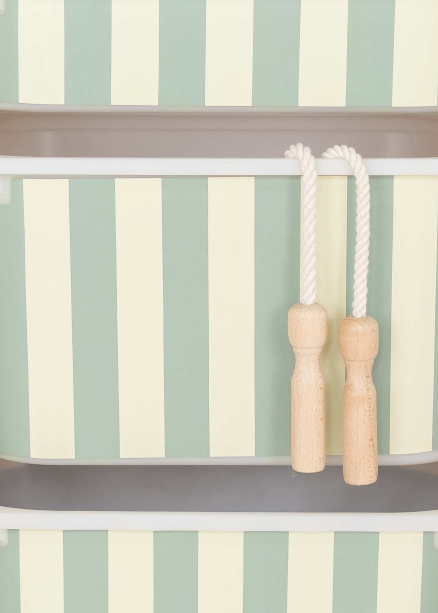 Kinderfreundliche Aufbewahrungsbox im IKEA TROFAST Regal mit grünem Streifenmotiv.