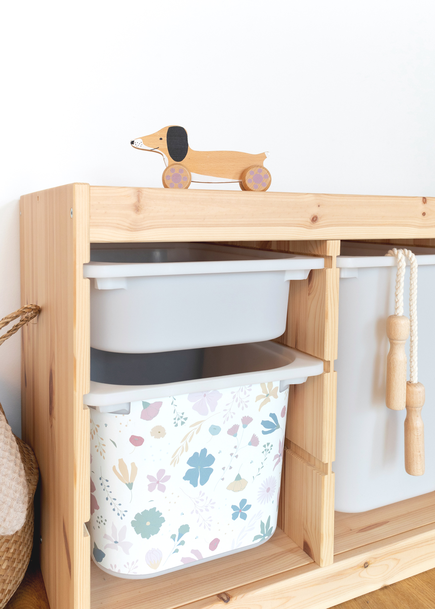 IKEA TROFAST Box mit Blütenmuster Ein IKEA TROFAST Regal im Zimmer, geschmückt mit einer bunten Klebefolie mit Blumenmuster.