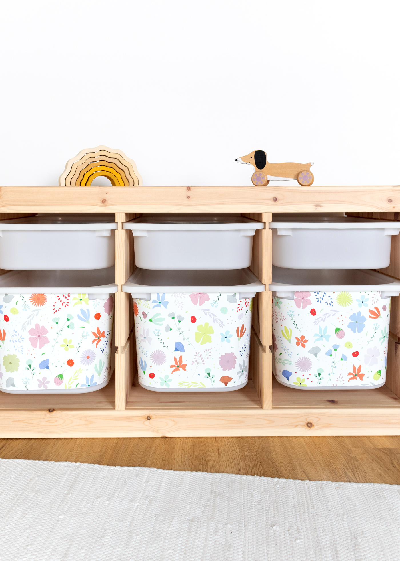 Ein IKEA TROFAST Regal im Zimmer, dekoriert mit einer farbenfrohen Klebefolie mit Blumenmuster
