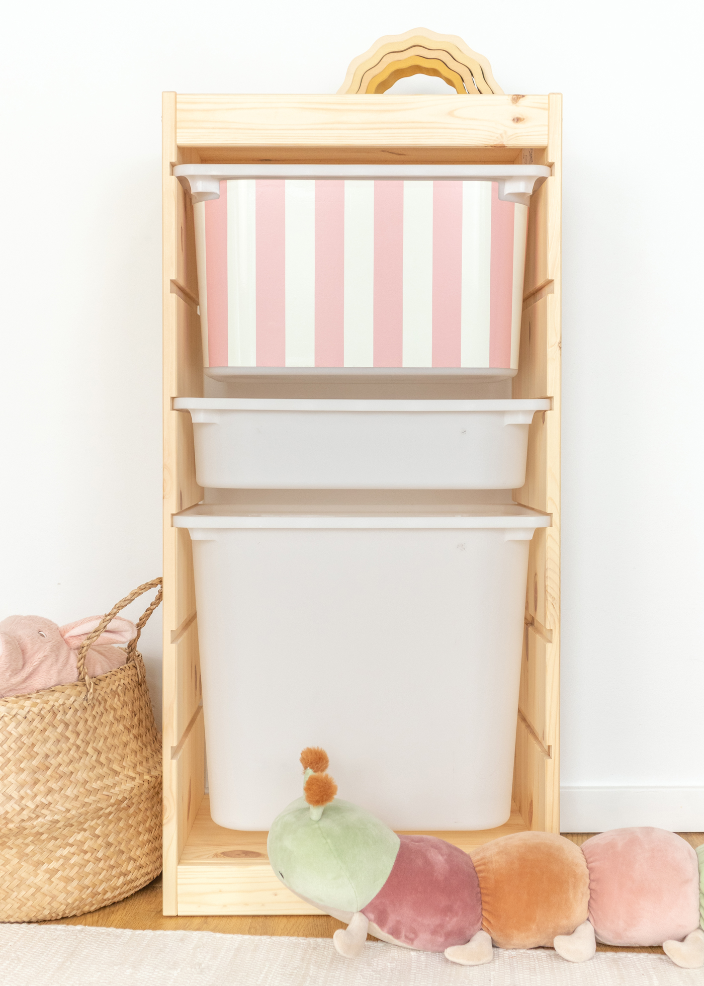Kinderfreundliche Box im IKEA TROFAST Regal, bedruckt mit einem fröhlichen rosa Streifenmuster.