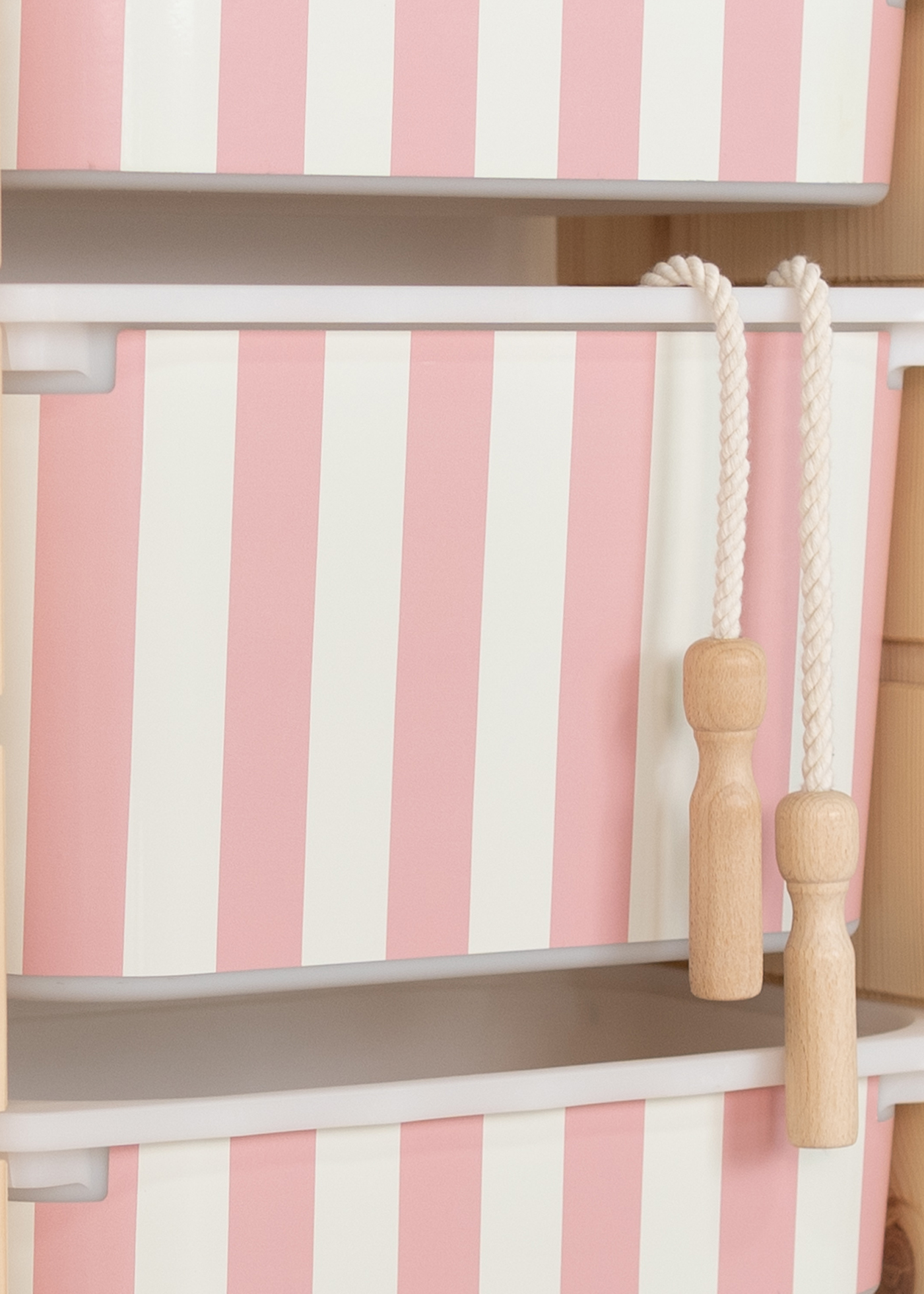 IKEA TROFAST Regal mit Aufbewahrungsbox, verziert mit einem verspielten rosa Streifenmuster.