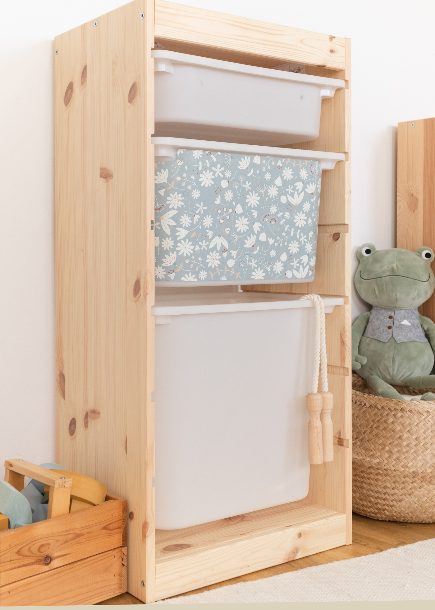 Aufbewahrungslösung mit grünem Blumenmotiv im IKEA Regal IKEA TROFAST Regal mit Aufbewahrungsbox, dekoriert mit einem fröhlichen grünen Blumenmuster.