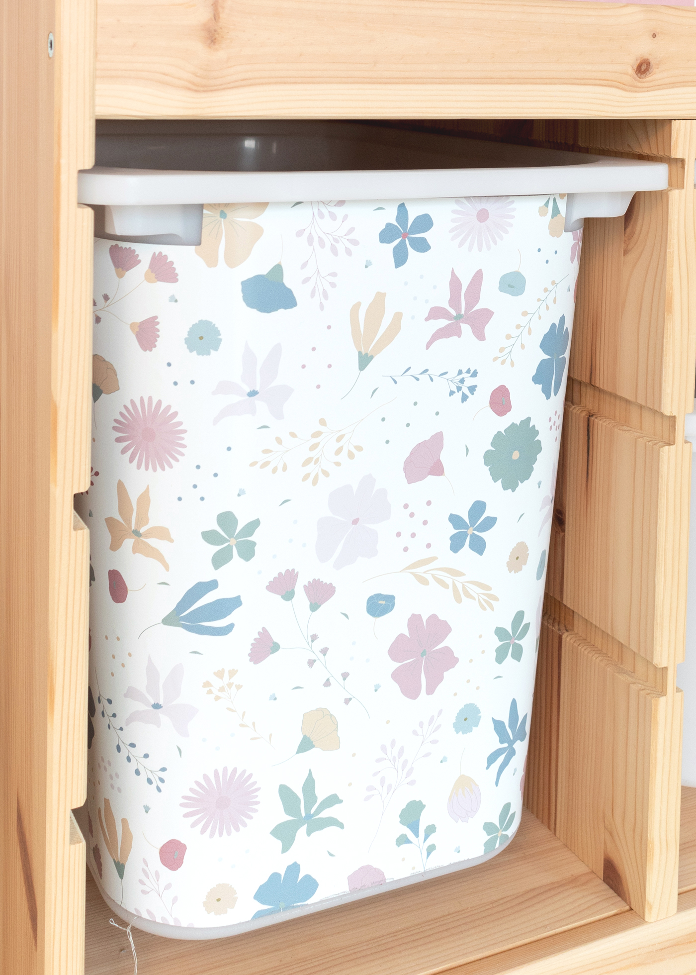 IKEA TROFAST Box mit Blumenmuster als Klebefolie Ein IKEA TROFAST Regal steht in einem Zimmer, beschmückt mit einer bunten Klebefolie mit Blumenmotiv