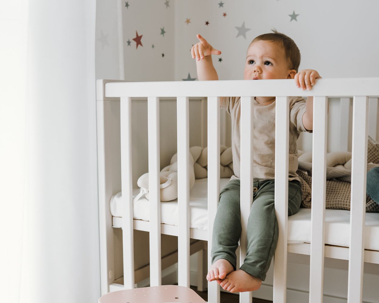 Baby im Babybett sitzend Baby im Babybett sitzend