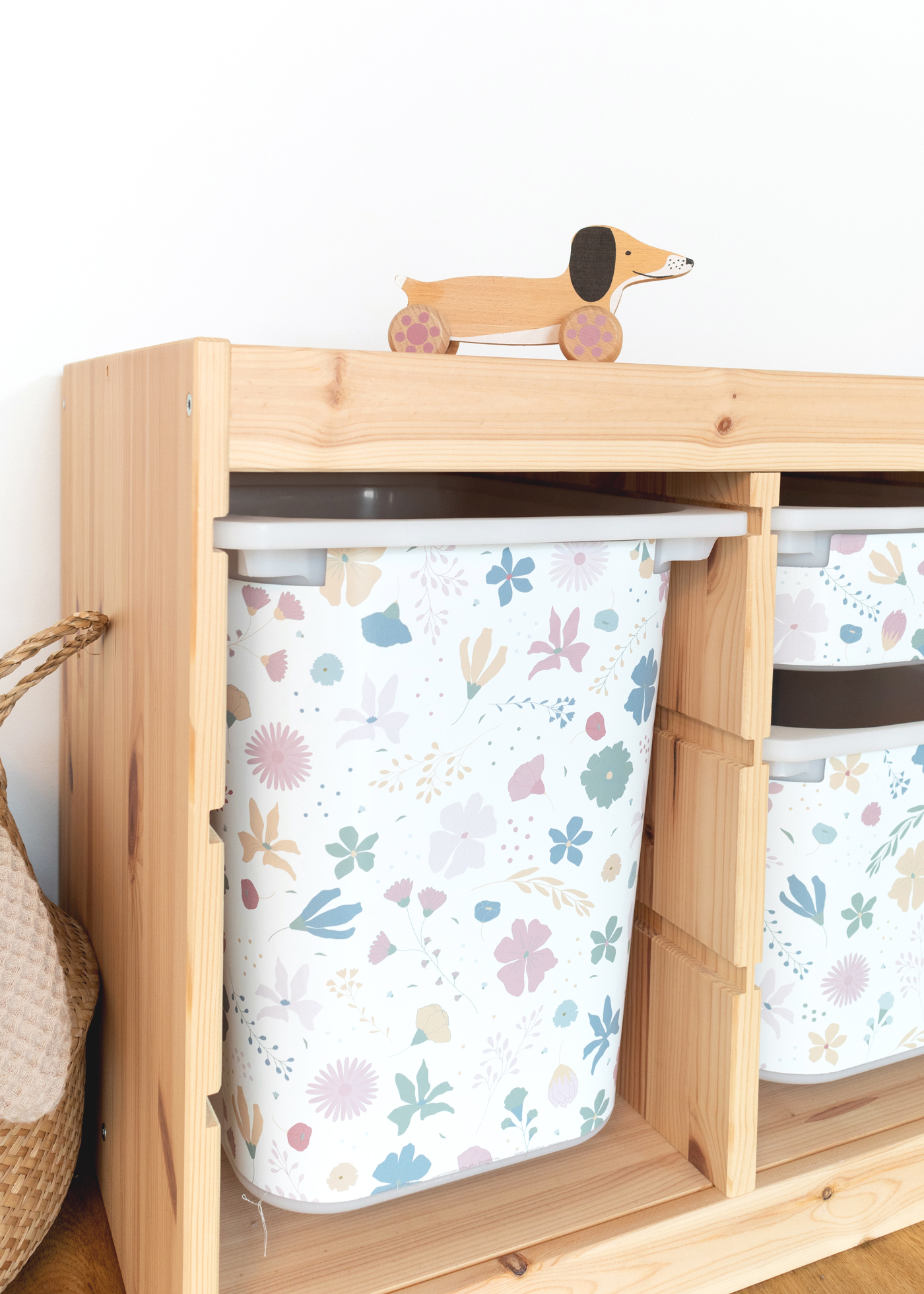 Blumenmuster IKEA TROFAST Regal Ein  IKEA TROFAST Regal steht in einem Zimmer, beschmückt mit einer bunten Klebefolie mit Blumenmotiv