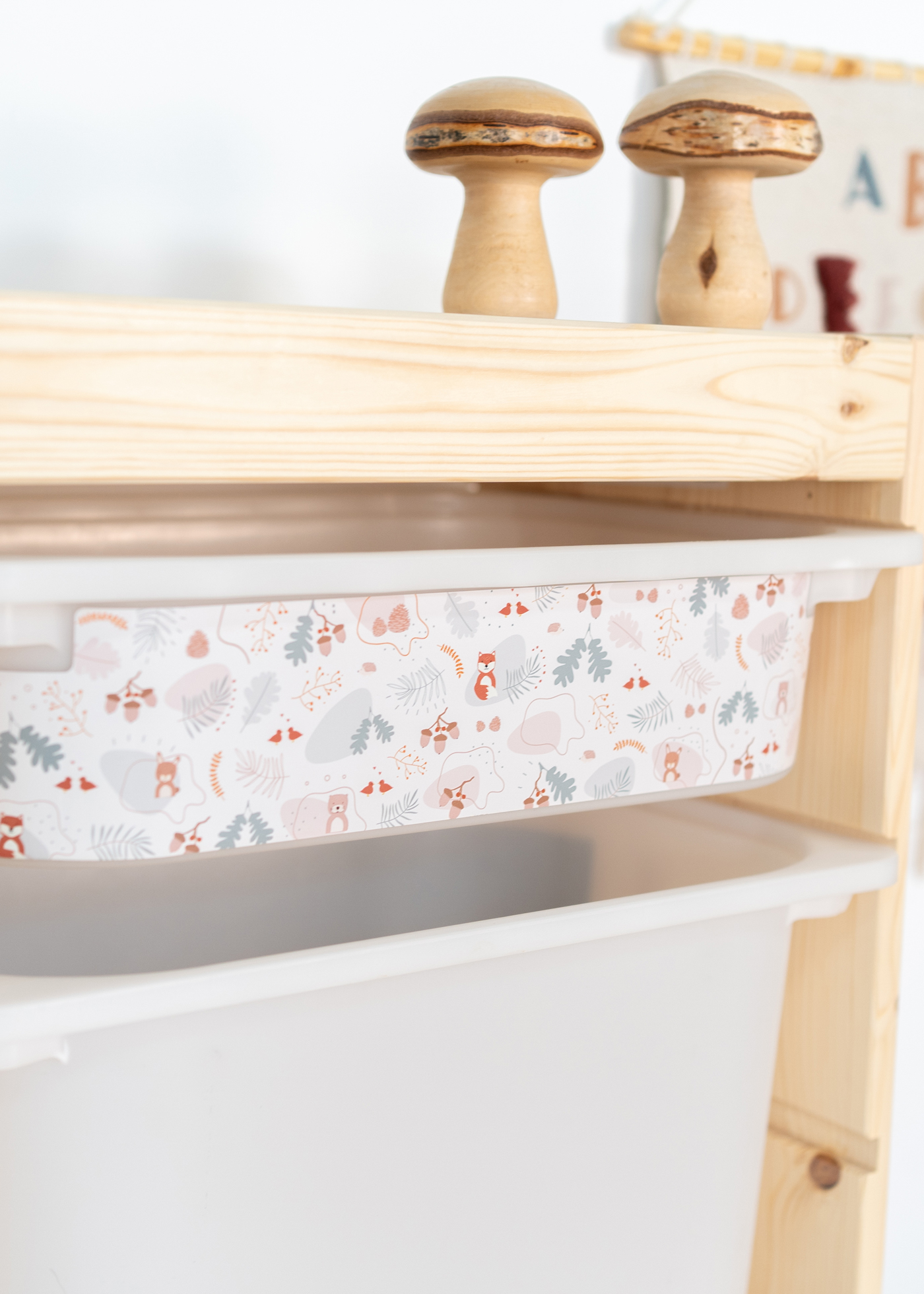 Aufbewahrungsbox im IKEA TROFAST Regal mit einem Waldmuster aus Fuchs, Reh und Otter, ideal für das Kinderzimmer.