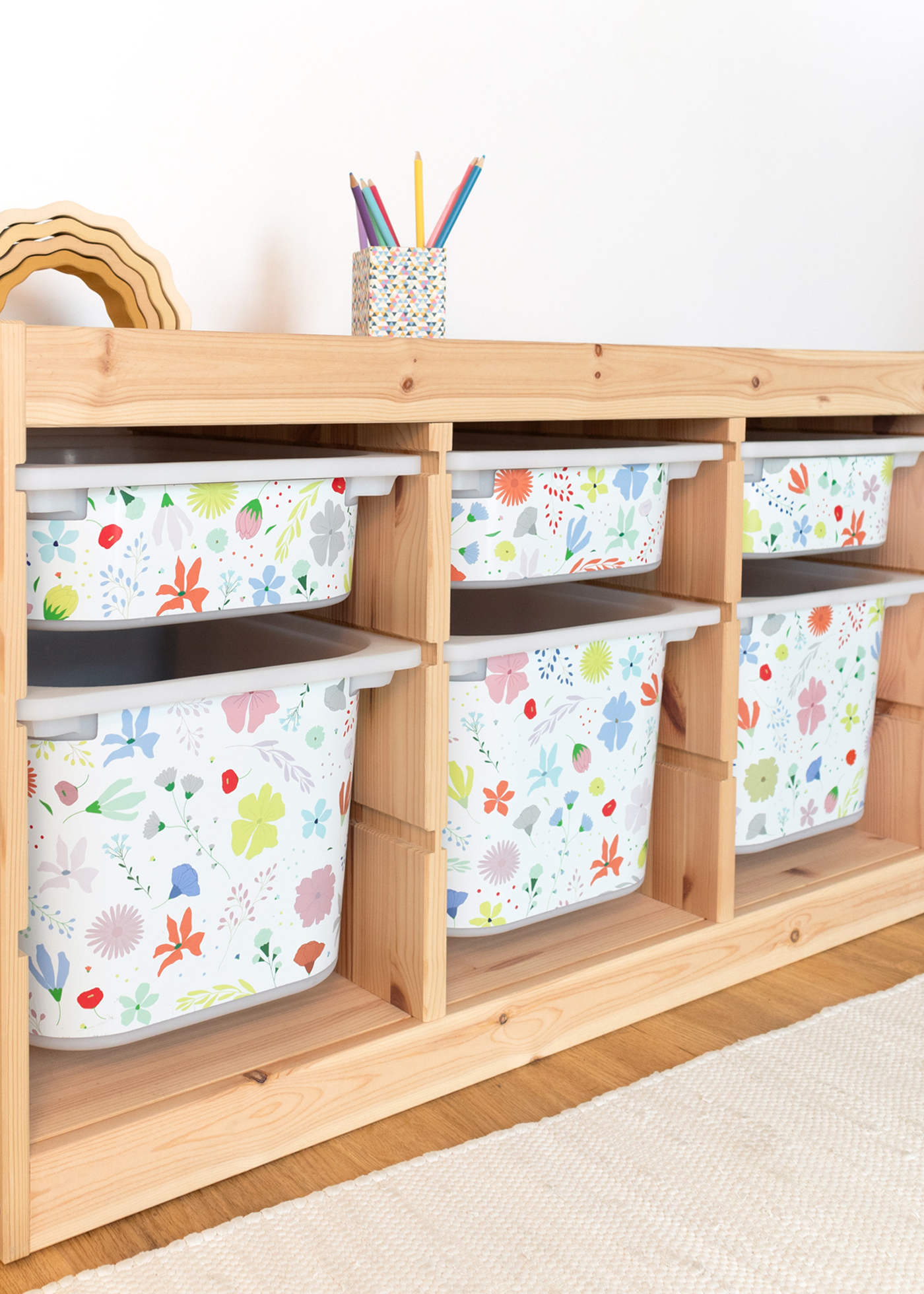 Ikea Boxen mit Blumenmuster Ein IKEA TROFAST Regal im Raum, verziert mit einer bunten Blumenmuster-Klebefolie
