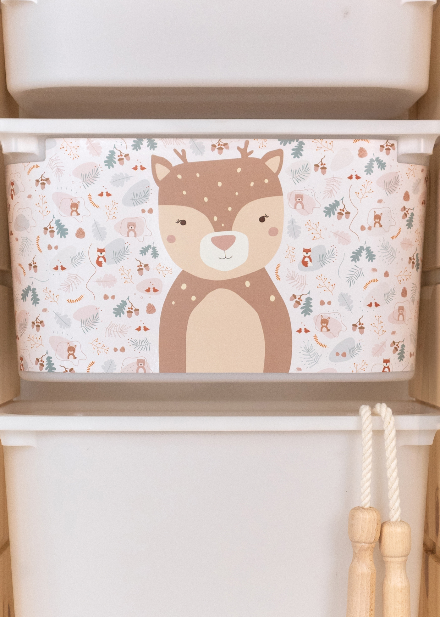 Aufbewahrungsbox im IKEA TROFAST Regal, dekoriert mit einem fröhlichen Reh-Motiv für das Kinderzimmer.