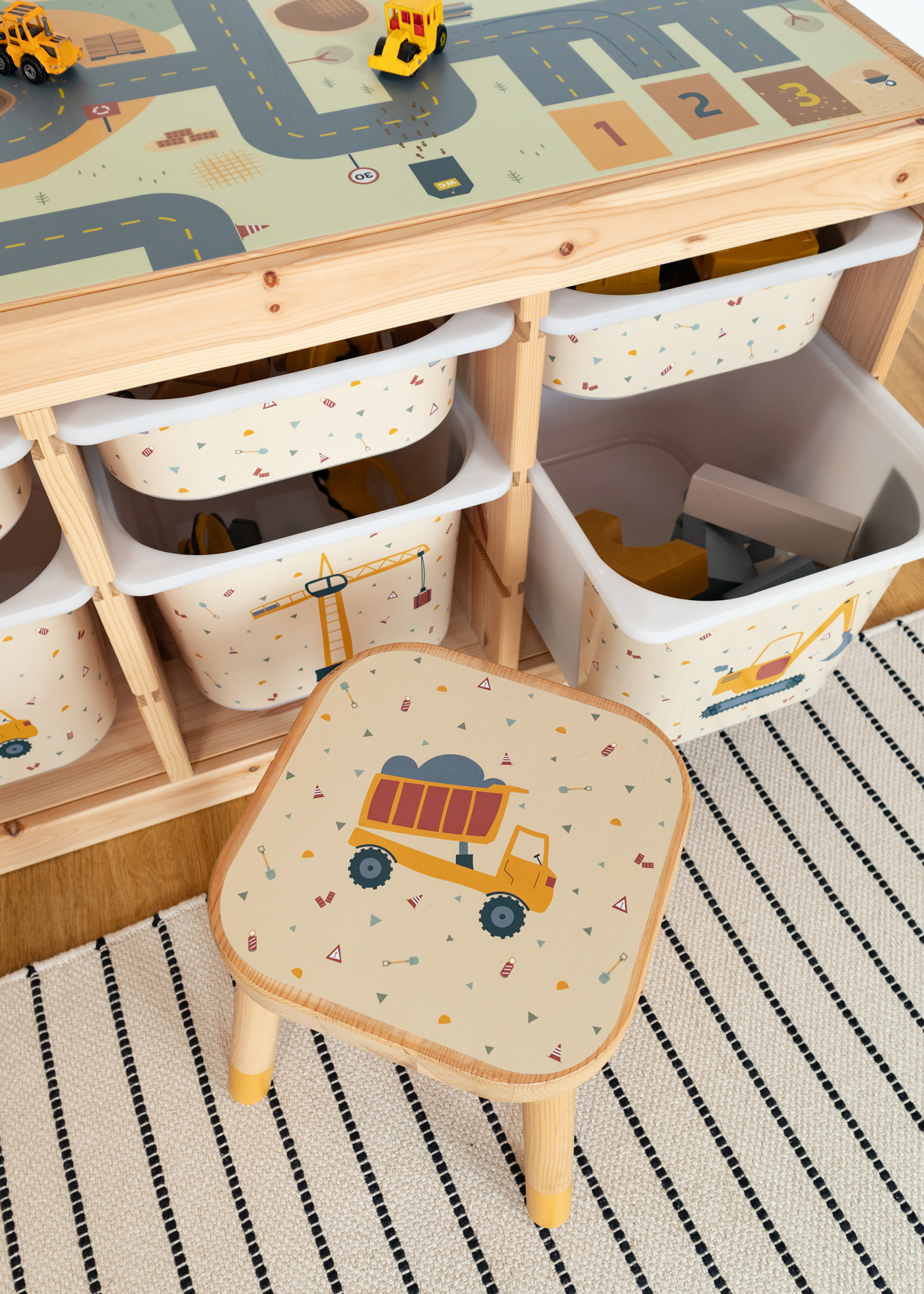 Ein IKEA FLISAT Kinderhocker mit Zubehör und Klebefolien von Limmaland mit Kipplader Motiv