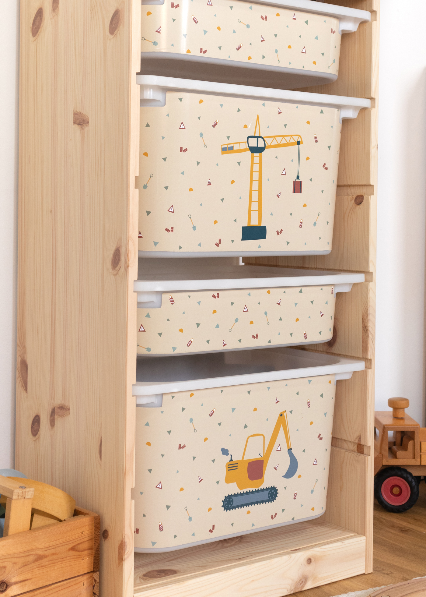 Beige Box im IKEA TROFAST Regal mit dekorativem Kran-Motiv für Kinder.